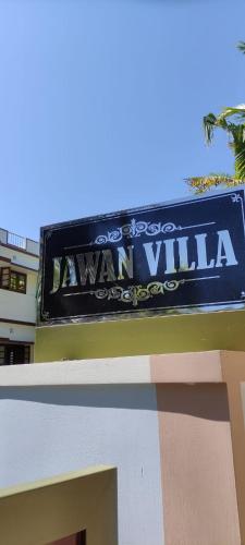 una señal azul en el lateral de un edificio en JAWAN VILLA, en Ernakulam