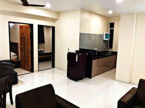 a living room with a kitchen with a refrigerator at SKYLARK STUDIO 1 in Belgaum