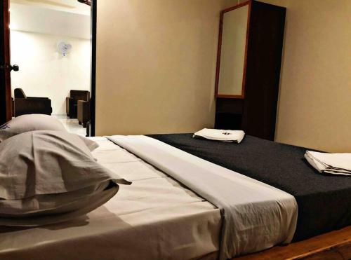 a large bed in a room with a mirror at SKYLARK STUDIO 1 in Belgaum