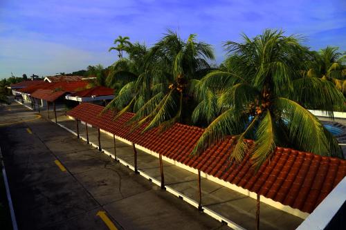 a row of buildings with palm trees and a fence at Hotel Sol del Oriente Iquitos in Iquitos