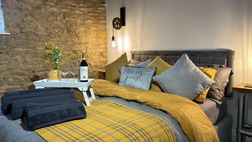 a bed with a yellow blanket and a table on it at The Old Stables in Northampton