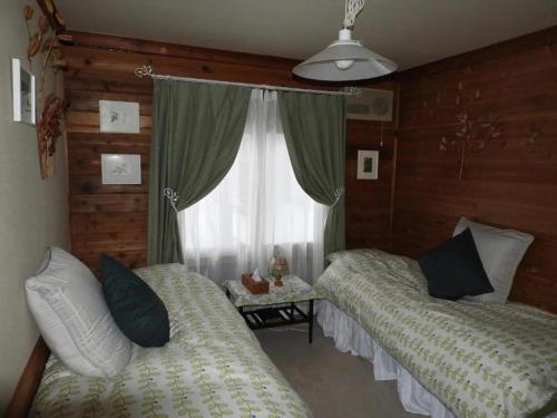 a bedroom with two beds and a window at 一棟貸し 露天風呂付き Snowfall Meteor in Kaminoyama