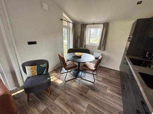 a small living room with a table and chairs at Vakantiepark Hertenhorst in Beekbergen
