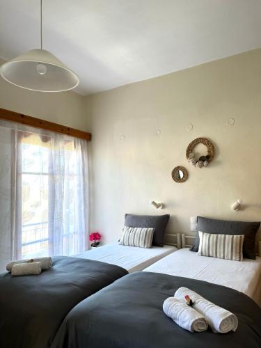two beds sitting next to each other in a bedroom at Nicoll Apartments in Acharavi