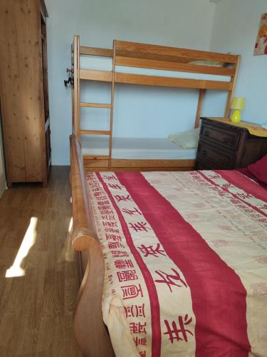 a bedroom with a bed with a ladder and a bedspread at Appart Sion face mer in Sion-sur-lʼOcéan