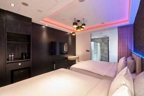 a hotel room with two beds and a tv at 和陽行館 Villa Bon Moment in Dayuan