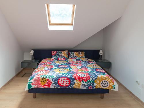 een bed met een kleurrijk dekbed en kussens bij Casa Bear Azuga in Azuga