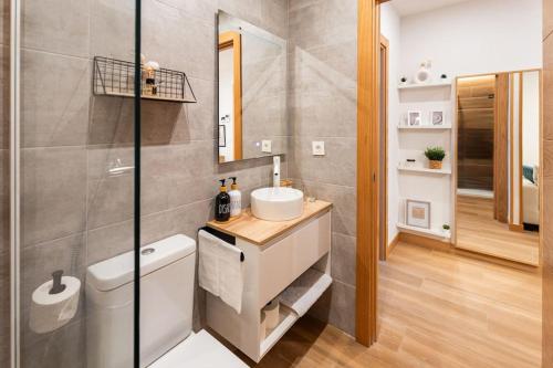 ein Badezimmer mit einem Waschbecken, einem WC und einem Spiegel in der Unterkunft OK home. in Gernika