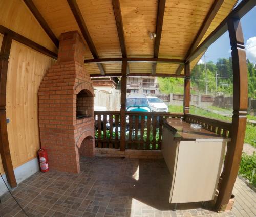 an outdoor kitchen with a brick oven on a patio at Casa Bear Azuga in Azuga