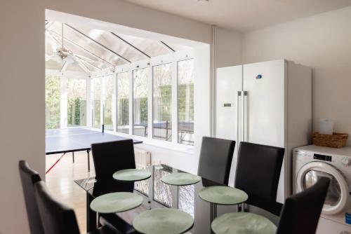 Una cocina y un comedor con mesa y sillas. en Ping-Pong Paradise, en Crawley