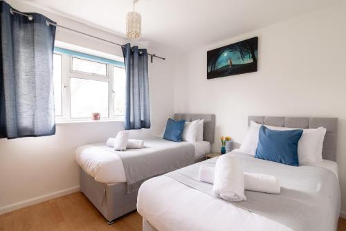 two beds in a room with blue and white at Ping-Pong Paradise in Crawley