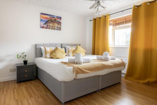 a bedroom with a large bed with yellow curtains at Ping-Pong Paradise in Crawley