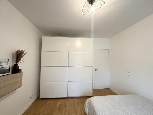1 dormitorio con armario blanco y cama en Comfy apartment near La Defense - West of Paris en La Garenne-Colombes