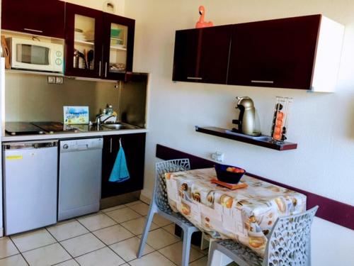 une cuisine avec une table et un évier et une table et des chaises dans l'établissement COPACABANA, à Canet