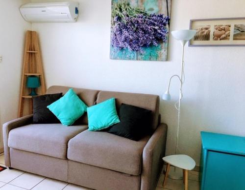 - un salon avec un canapé marron et des oreillers bleus dans l'établissement COPACABANA, à Canet