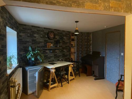 ein Wohnzimmer mit einem Tisch und einem Klavier in der Unterkunft Bergerie Francique in Lachaussée