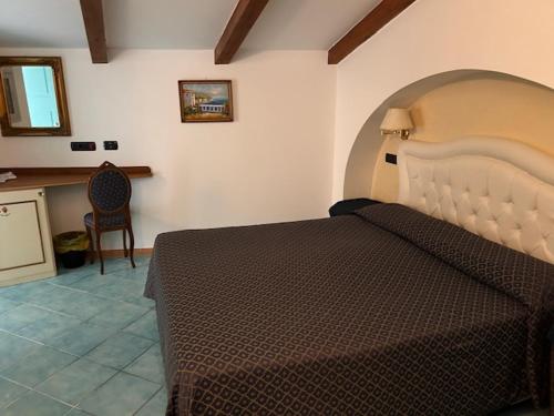 a bedroom with a large bed and a chair at Palazzo Vingius in Minori