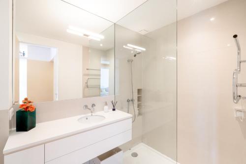 a white bathroom with a sink and a shower at VIVA Nanda's Place in Porto