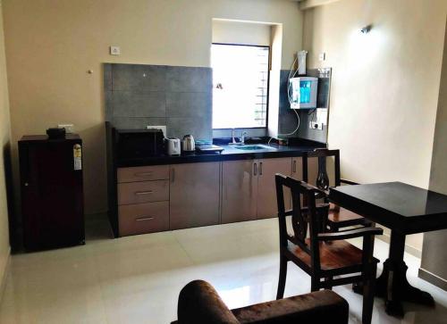 a kitchen with a table and a table and a chair at SKYLARK STUDIO 2 in Belgaum