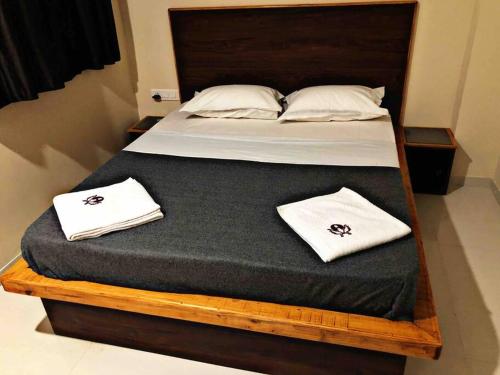 a large bed with two white towels on it at SKYLARK STUDIO 2 in Belgaum
