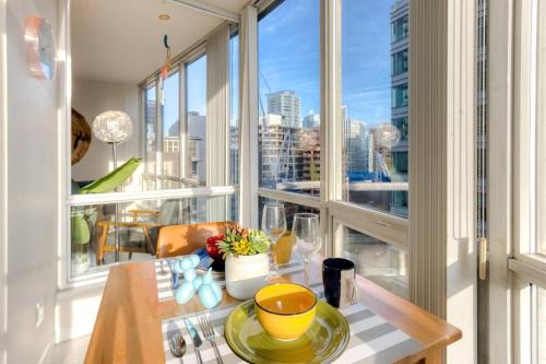 una sala da pranzo con tavolo e una grande finestra di lean & Cozy 1 Bedroom by Convention Center incl. Parking a Vancouver