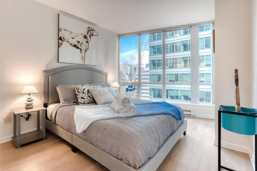 a bedroom with a bed and a large window at lean & Cozy 1 Bedroom by Convention Center incl. Parking in Vancouver