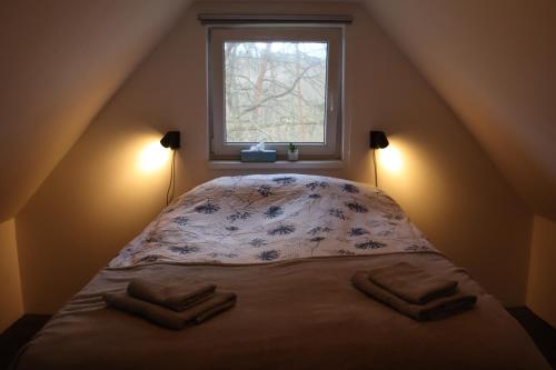a bed in a room with a window at Domeček u Brna, klid & wi-fi in Bílovice nad Svitavou