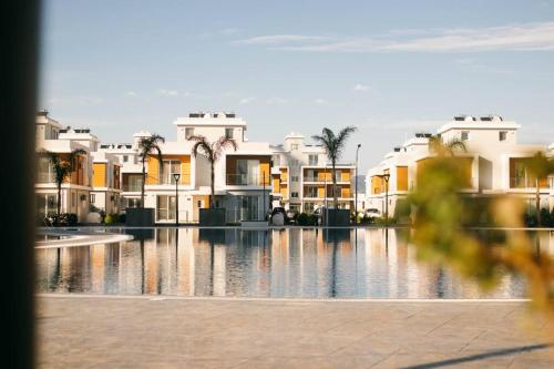 a group of houses in front of a swimming pool at A 1 Bedroom in Royal Sun Elite, in Long Beach in İskele