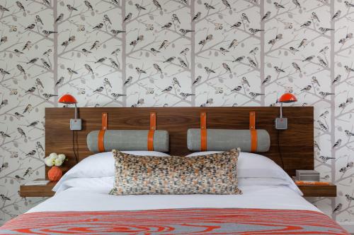 a bedroom with a bed with a bird patterned wall at Field Guide Lodge in Stowe