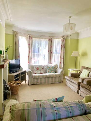 a living room with a couch and a tv at Welcoming Southwold Holiday Home in Southwold