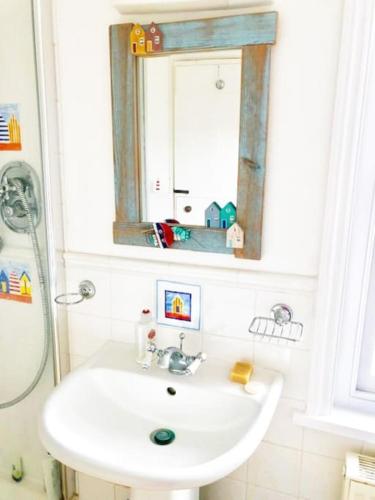 a bathroom with a sink and a mirror at Welcoming Southwold Holiday Home in Southwold