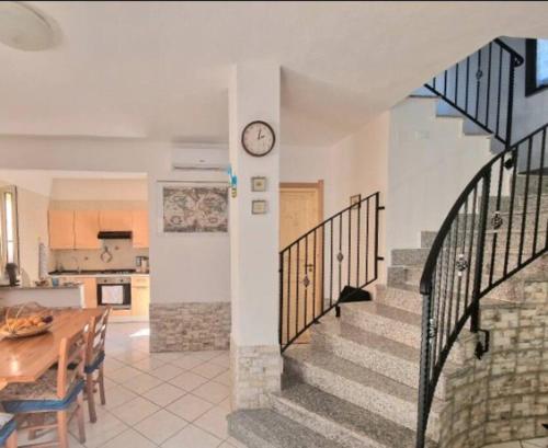 een keuken en een eetkamer met een klok aan de muur bij Villa Susy Solanas -IUN R5389 in Solanas