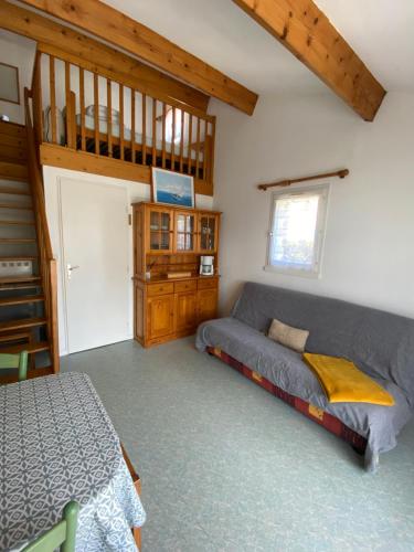 a bedroom with a bed and a staircase in a house at Maisonnette dans résidence vacances, à 200m de la plage in Bretignolles-sur-Mer