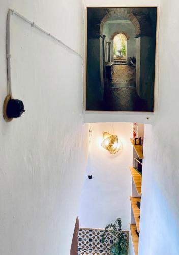 a hallway with a painting hanging on a wall at Alojamiento La Casa del Pintor in Almonaster la Real
