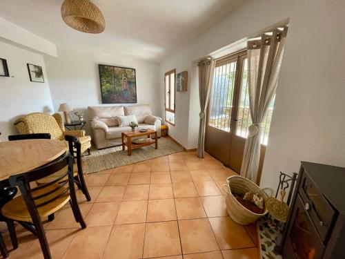 een woonkamer met een tafel en een bank bij Alojamiento La Casa del Pintor in Almonaster la Real
