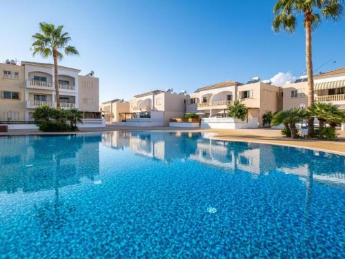 una gran piscina con palmeras y edificios en Mermaid Holiday Apartments, en Mandriá