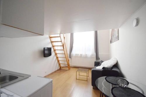 - un salon avec un canapé noir et une échelle dans l'établissement Beau studio mezzanine meublé, à Courbevoie