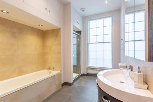 a bathroom with a tub and a sink and a bath tubermott at Luxury Spacious Flat For 4 Guests & Free Parking in Nottingham