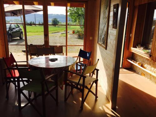einen Tisch und Stühle in einem Zimmer mit Fenster in der Unterkunft Gîte Les Cigognes in Orchamps-Vennes