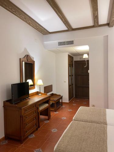 a bedroom with a desk with a tv and a mirror at Hotel Rural Cazorla Posada del Cordobés in Cazorla