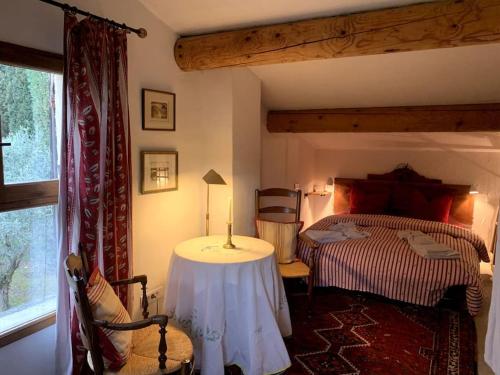 une chambre avec un lit avec une table et une fenêtre dans l'établissement Dreamy guesthouse amidst a marvellous property, à Caromb