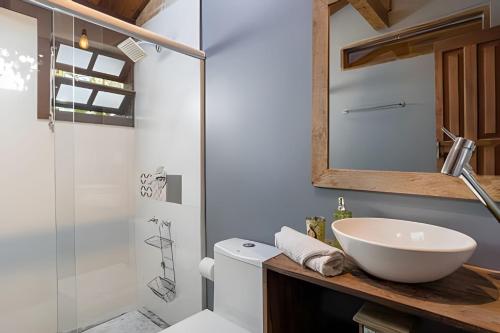 a bathroom with a sink and a toilet and a shower at Casa Thai Linda na Praia in Barra de Ibiraquera