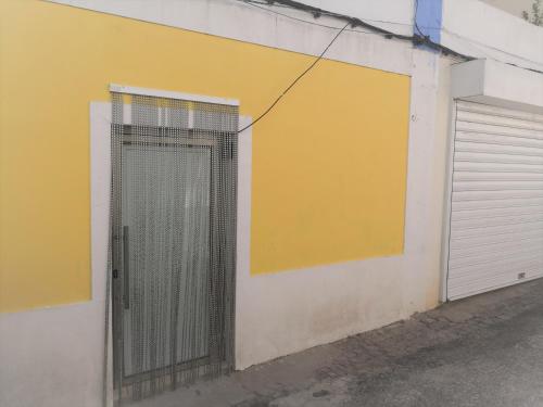 um portão ao lado de uma parede com uma garagem em Casa térrea no centro da Cidade, antiga adega! em Borba