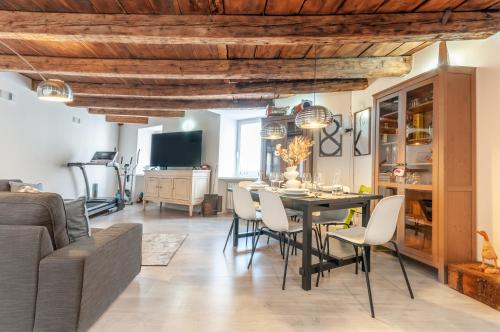 - une salle à manger et un salon avec une table et des chaises dans l'établissement Contrada della Fontana Luxury Apartment, à Levico Terme