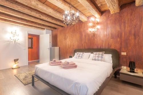 1 dormitorio con 1 cama blanca grande y paredes de madera en Contrada della Fontana Luxury Apartment en Levico Terme