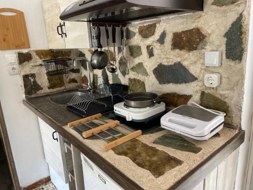 a kitchen counter with a stove and a sink at Efi studios 2 in Kardamaina