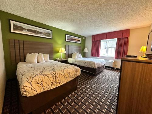 a hotel room with two beds and green walls at Rodeway Inn Huron in Huron