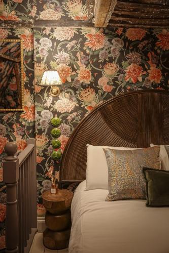 a bedroom with a bed with a floral wallpaper at Daylily Cottage - Two Bedroom Georgian Cottage in Central Bath in Bath
