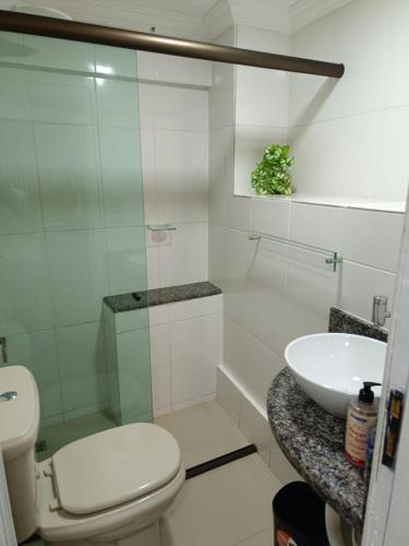 a white bathroom with a toilet and a sink at Aconchego Vila Rica - Mariana in Mariana