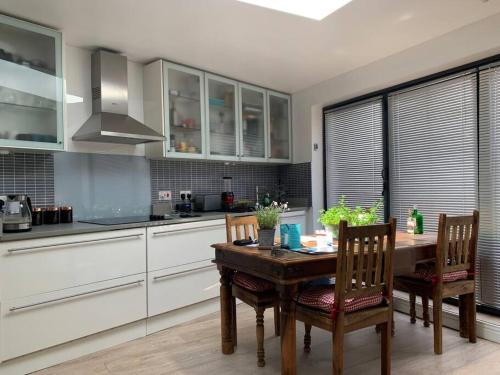 a kitchen with a wooden table and chairs in it at Entire Bungalow with 2 car Parking.Stunning views in Bath